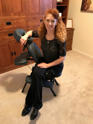 Lorie on her mobile massage chair after a Twin Cities chair massage event